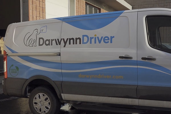 Darwynn Driver branded delivery van parked outside a warehouse for last mile delivery service in Canada.